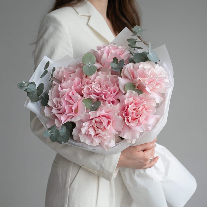 Букет из семи нежно-розовых французских роз с эвкалиптом в белой упаковке на подарок девушке